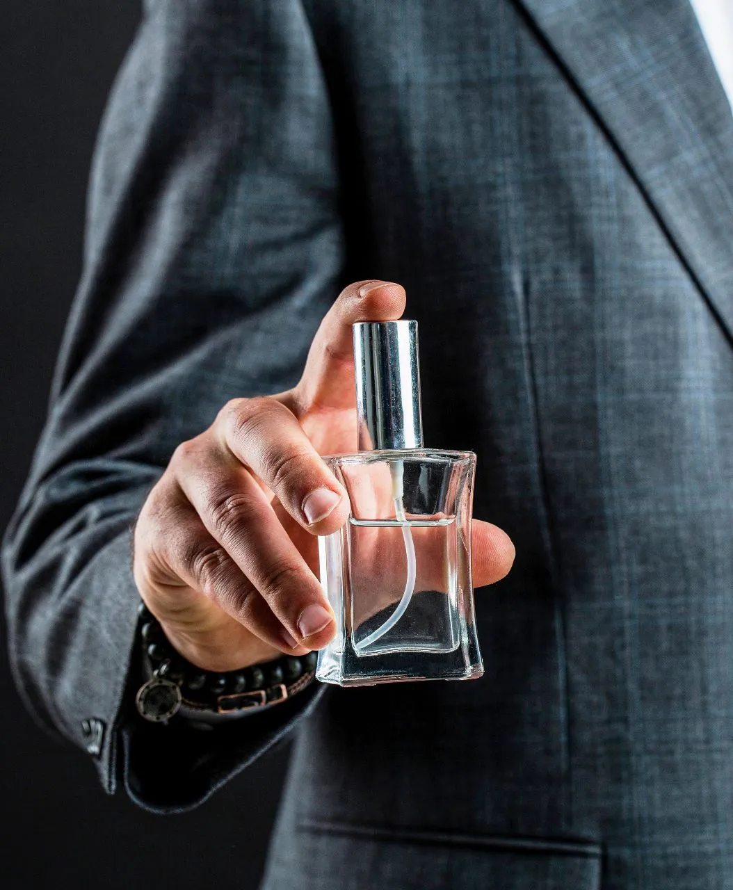 Man in a suit applying perfume
